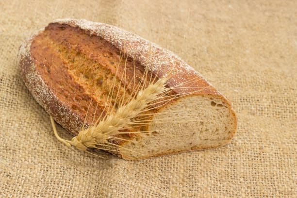istock Brown sprouted bread and wheat ear closeup on sackcloth 924709128