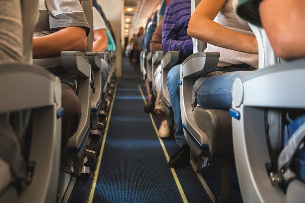 cabin of airplane with passengers on seats stock photo