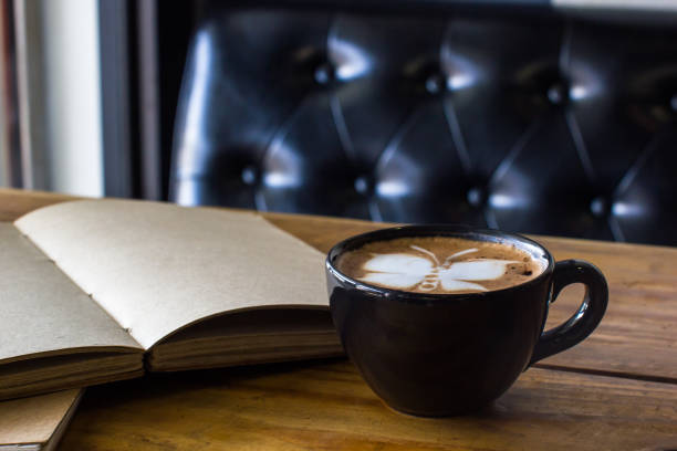 istock Latte art coffee on wooden table with open blank handmade book background. 924720304