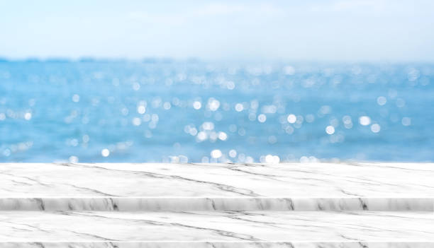 istock Empty white marble table top with blur blue sky and sea boekh background in sunny day,Mock up template for display or montage of product or content use as banner in social media ads 924724542