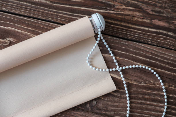 istock The beige rolled blind is on a wooden surface. 924727636