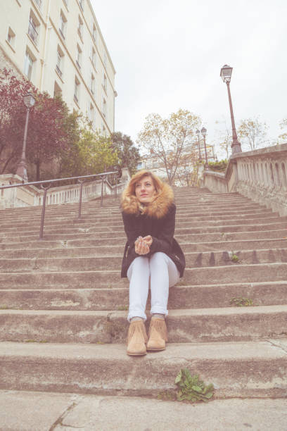 istock Cute smiley girl sitting alone on a big staircase. 924727814