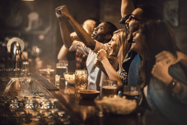 istock Young excited fans having fun in a bar while cheering for their favorite team. 924728234