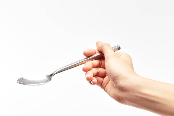 istock woman's right hand holds a spoon on a white background. 924732670