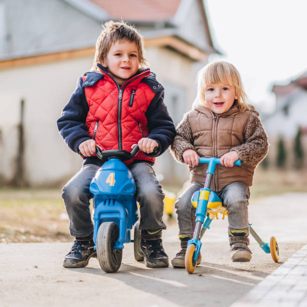 istock Two happy boys enjoying on their three wheeled vehicles. 924732962