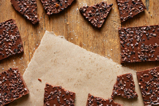 istock Frame of chocolate pieces on wooden table with space for text. 924740386