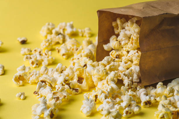 istock Popcorn in paper bag on yellow table 924741100