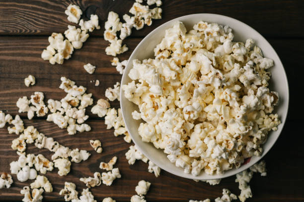 istock Popcorn in bowl on wooden background, top view 924741454