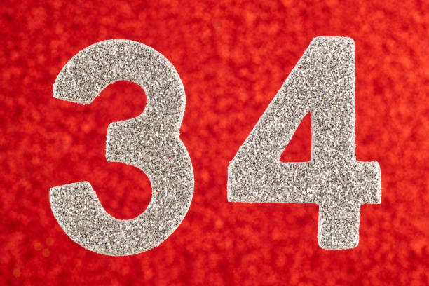 istock Number thirty-four silver color over a red background. Anniversary 924741810