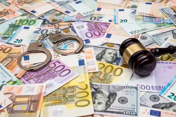 Photo of crime concept - handcuffs, gavel dollar and euro bills