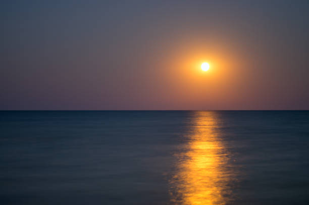 istock moon in the night sky, sea horizon 924745120