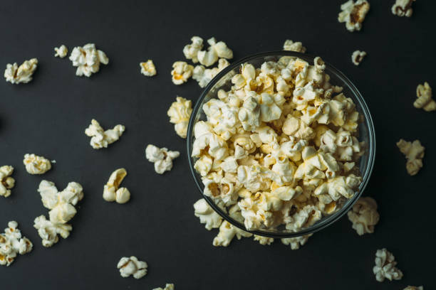 istock Popcorn in glass bowl on dark background, top view with copy space 924745674