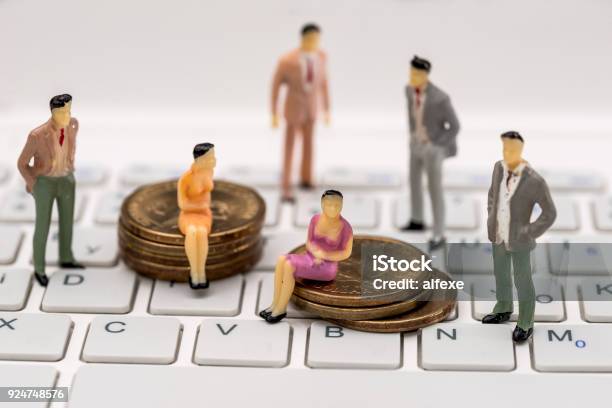 Small Toy People Are Standing On A Laptop And Sitting On Coins Stock Photo - Download Image Now