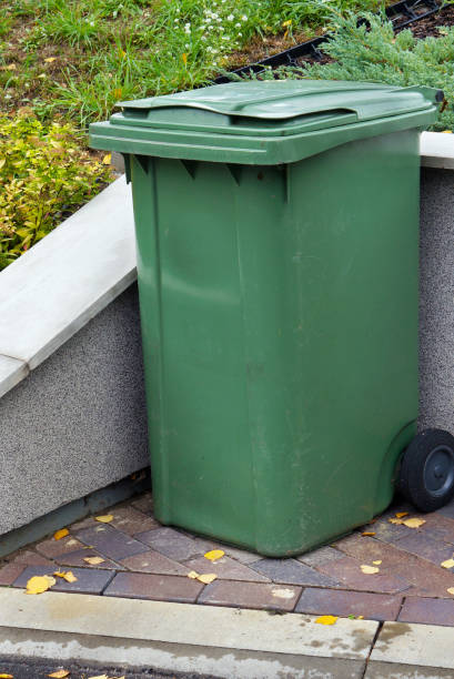 istock Green plastic standard garbage container installed near the village house 924759834