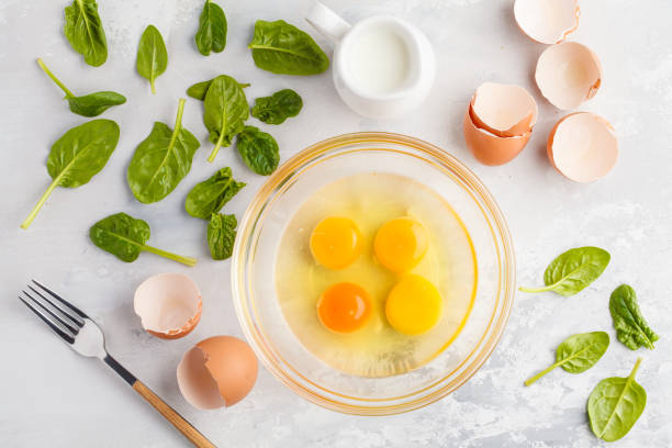 Raw ingredients for omelette with milk and spinach. Breakfast concept, top view, copy space.