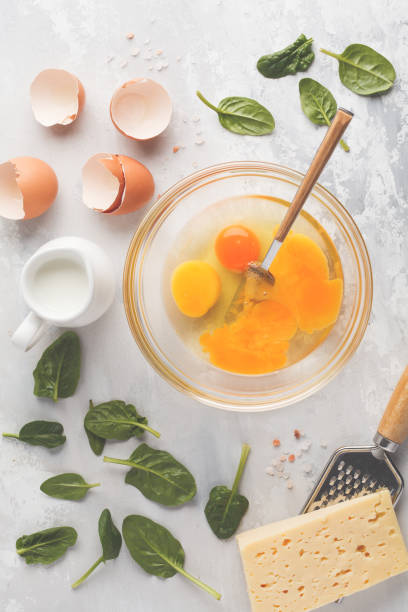 istock Raw ingredients for omelette with cheese and spinach. Breakfast concept, top view, copy space. 924761436