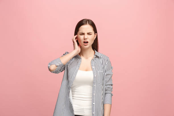 die ohrenschmerzen. die traurige frau mit kopfschmerzen oder schmerzen auf eine rosa studio-hintergrund - european culture audio stock-fotos und bilder