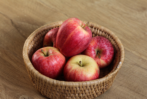 close up of royal gala apples in straw basket