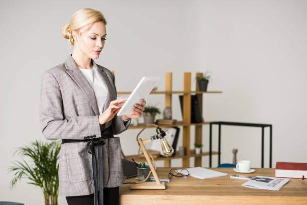 istock portrait of confident businesswoman using tablet while standing at workplace in office 924773328