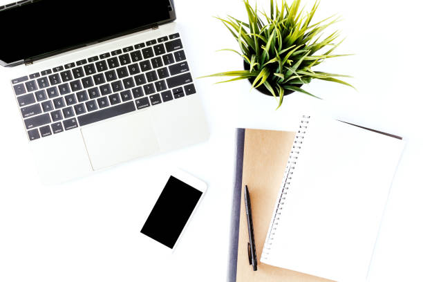 istock Top view of laptop computer and notebook on white office desk table.Flat lay 924784388