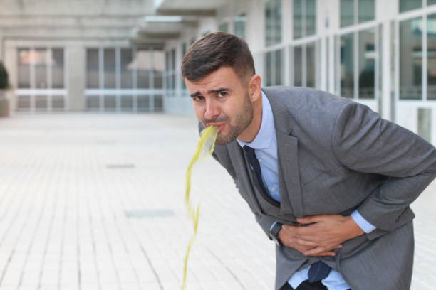 Sick businessman throwing up in the office Sick businessman throwing up in the office. puke green color stock pictures, royalty-free photos & images
