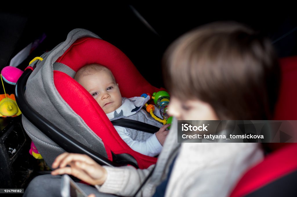 Niño pequeño y su hermano mayor, viajar en asientos de coche, ir de vacaciones - Foto de stock de A la moda libre de derechos