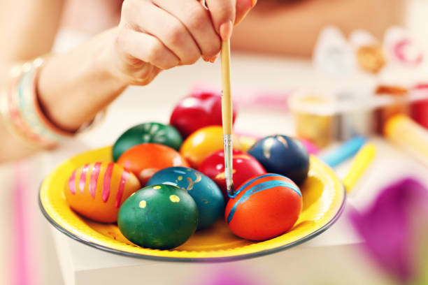 istock Attractive woman painting Easter eggs at home 924804748