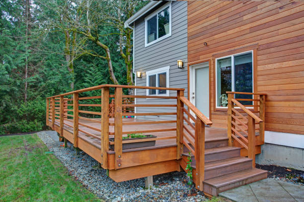 Charming newly renovated home exterior with mixed siding Charming newly renovated home exterior, natural wood siding and grey siding create a beautiful curb appeal. Detail view of a nice walk out deck with wooden handrails. siding building feature photos stock pictures, royalty-free photos & images