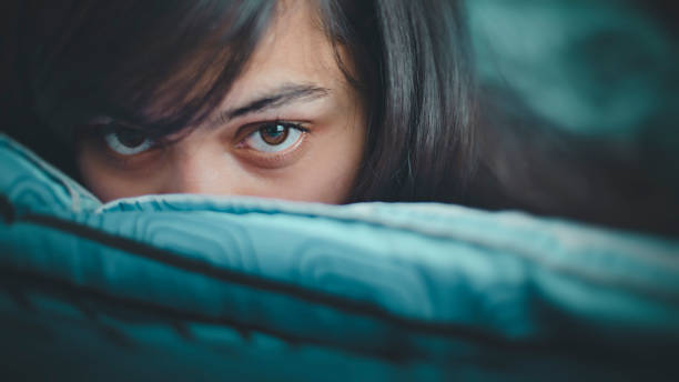istock Young woman peeping over the pillow. 924813382
