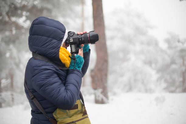 istock Woman shooting with camera in mountain with snow 924813858