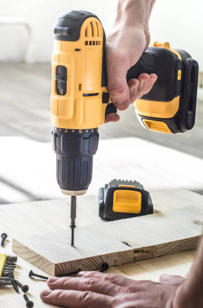 istock yellow screwdriver on a wooden table, screws, a set of bits. 924820588