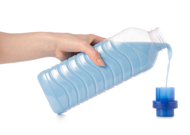 istock Softener conditioner in blue plastic bottle in hand isolated on white background 924825842