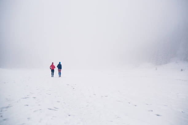 istock Two women trail running on snow in winter mountains 924830044