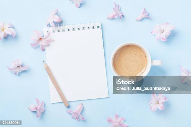 Notebook Cup Of Coffee And Pink Flowers On Blue Pastel Background Top View Fashion Woman Working Desk Spring To Do List Stock Photo - Download Image Now