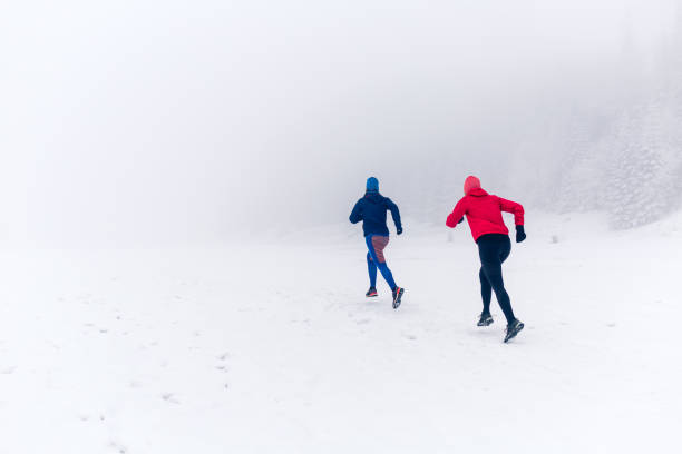 istock Two women trail running on snow in winter mountains 924832510