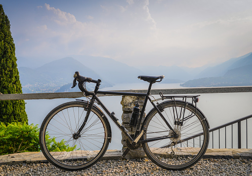 Touring bicycle next to railing with the beautiful view of Lake Como, Lombardy, Italy towards Bellagio. Captured in Varenna