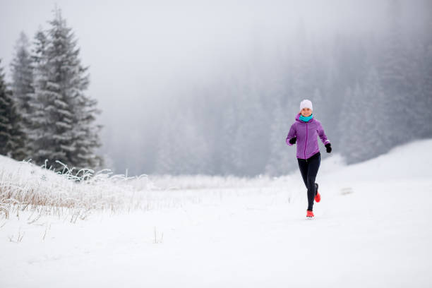 ragazza che corre dietro le montagne invernali - journey footpath exercising effort foto e immagini stock