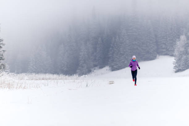 ragazza che corre dietro le montagne d'inverno - journey footpath exercising effort foto e immagini stock