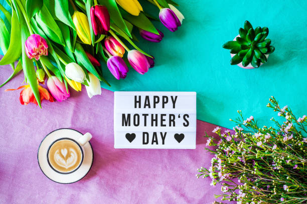 Happy mother's day written in lightbox with spring flowers from above