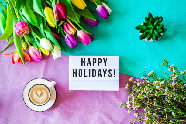 istock Happy holidays written in lightbox with spring flowers from above 924836898