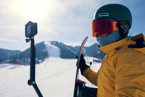 one snowboarder use action camera taking selfie on winter ski resort piste
