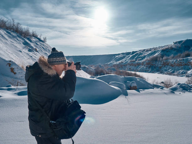 istock A man with a camera in his hands examines the plain covered with snow. 924841678