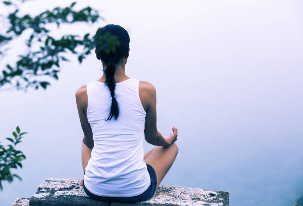 istock One woman practicing yoga at mountain peak 924841820