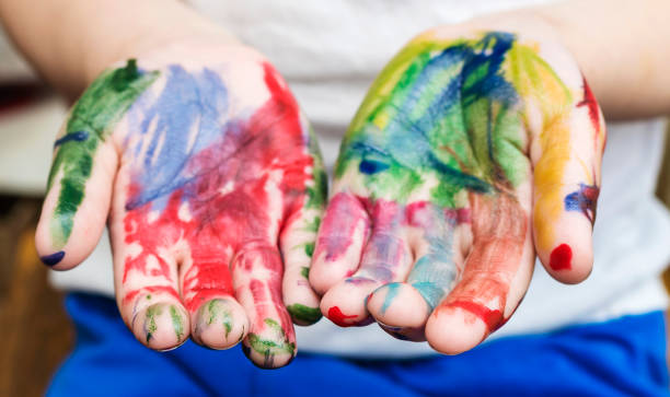 istock Child's hands covered in multicolored paint. Close-up, selective focus. 924842066