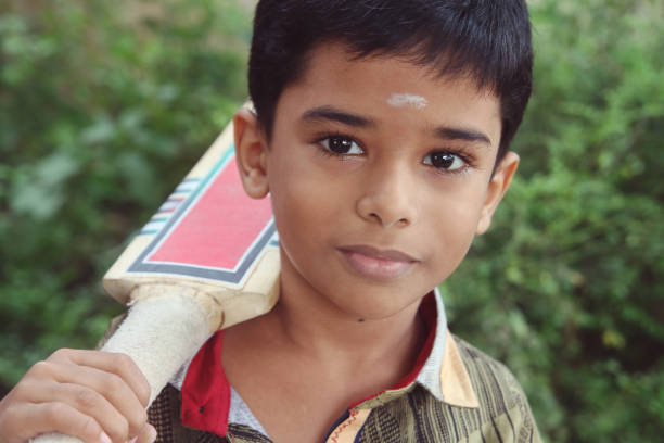 istock Indian boy posing to camera with cricket bat 924845154