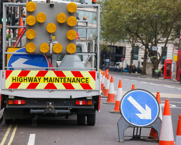 escena de obras de calle de londres con el mantenimiento de la carretera coche y señal de tráfico derecho - traffic cone uk street london england fotografías e imágenes de stock