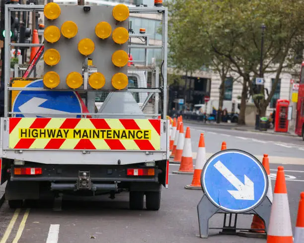 London street barricaded with Highway Maintenance vehicle and traffic cones with Keep Right diversion traffic sign - roadworks concept