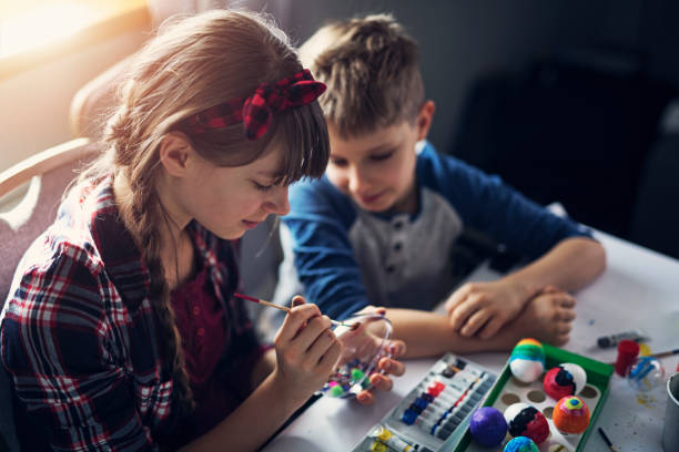 istock Brother and sister painting modern easter eggs 924849422
