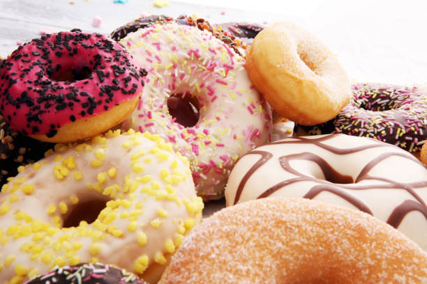 istock assorted donuts with chocolate frosted, pink glazed and sprinkles donuts. 924850202