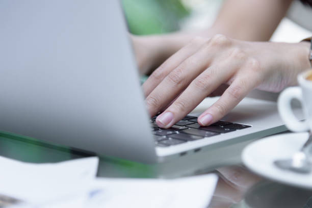 istock Asian woman hands has touching and typing on laptop computer with blurred coffee, computer and view outside window. 924850264
